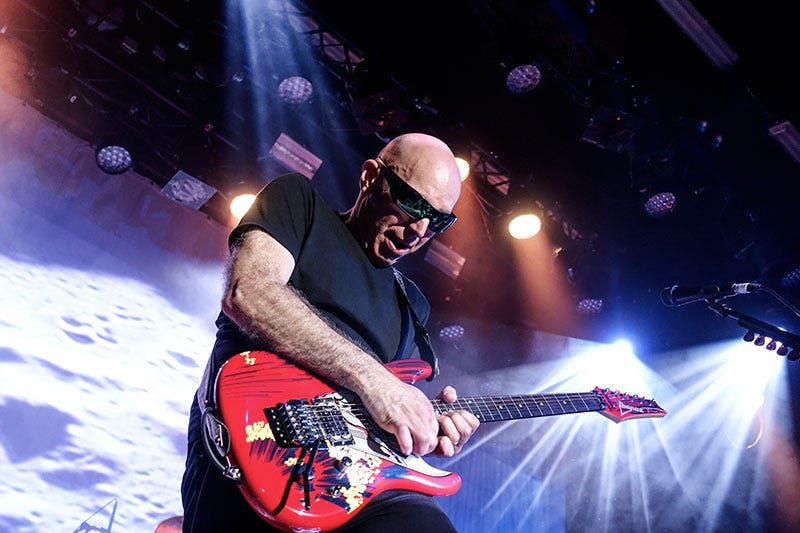 Joe Satriani plays guitar at a show